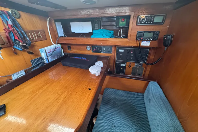Slide: The Image of Navigation station inside a 1985 Beneteau First 38 sailboat, featuring control panels and seating. - 29