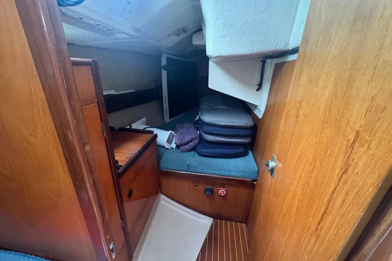 Slide: The Image of 1985 Beneteau First 38 cabin interior with wooden finish and storage area. - 36