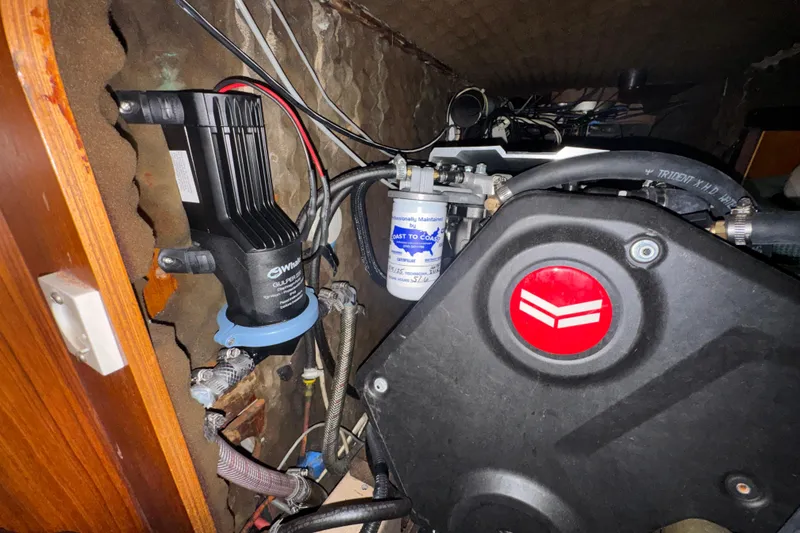 Slide: The Image of Engine compartment of a 1985 Beneteau First 38 sailboat, featuring mechanical components and wiring. - 38