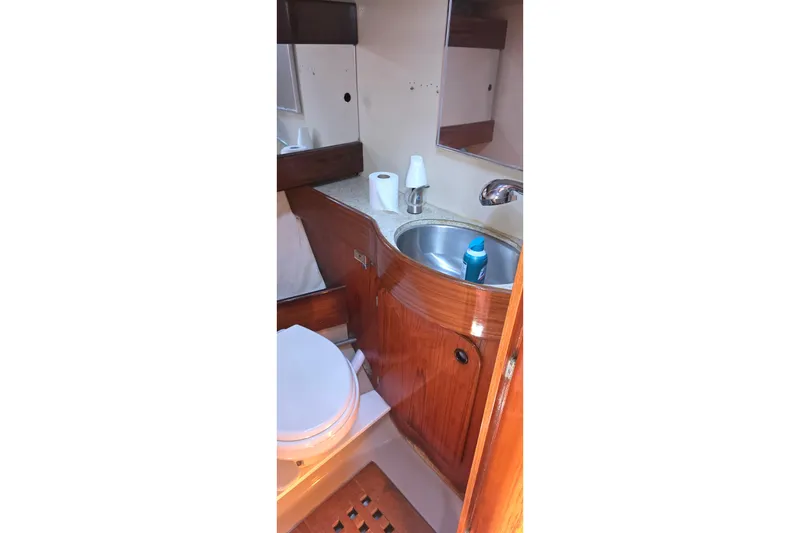 Slide: The Image of 1985 Beneteau First 38 yacht bathroom with wooden cabinetry and stainless steel sink. - 41
