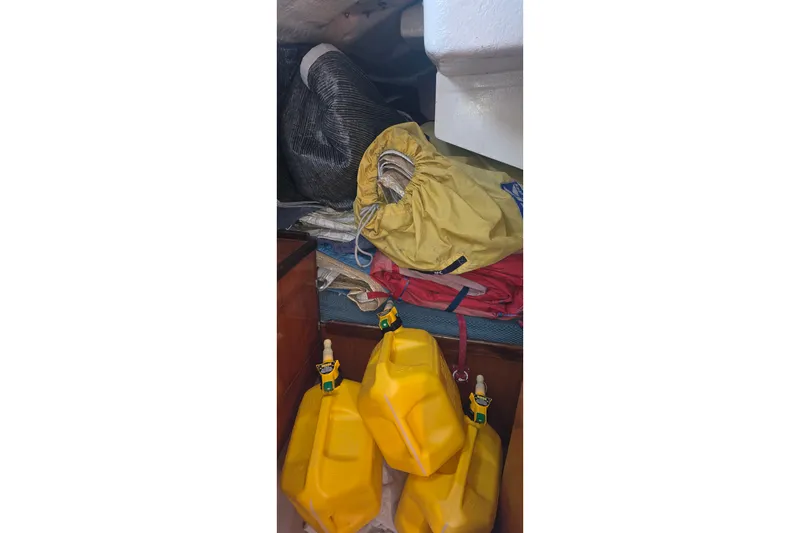 Slide: The Image of Storage area in a 1985 Beneteau First 38 sailboat with yellow fuel containers. - 43
