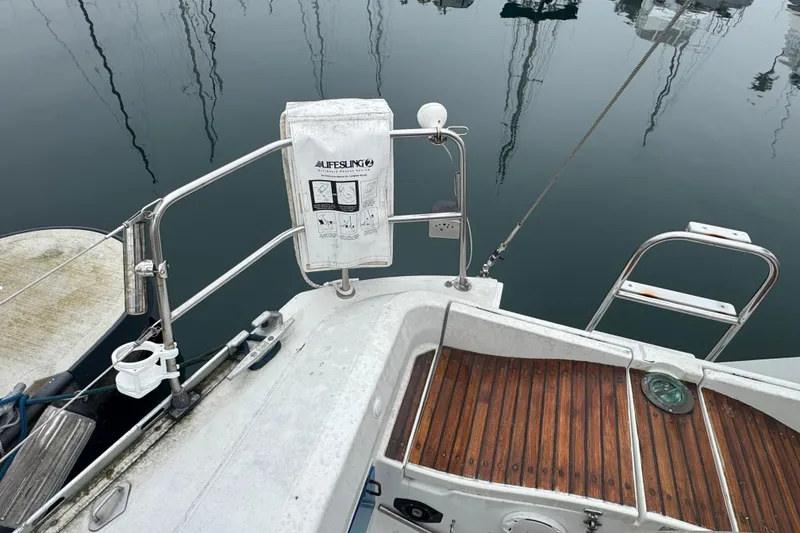 Slide: The Image of Stern view of 1985 Beneteau First 38 sailboat with lifesaving equipment and wooden deck. - 5