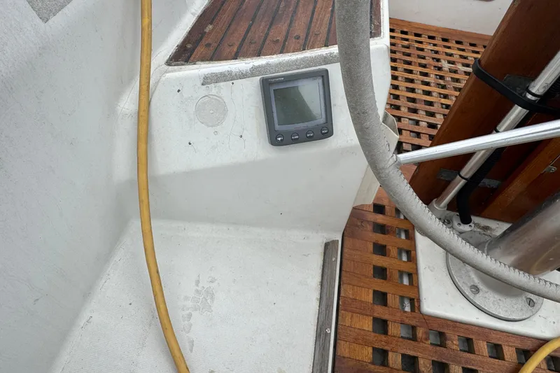 Slide: The Image of Cockpit of 1985 Beneteau First 38 sailboat with wooden flooring and navigation display. - 9