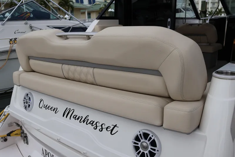 Slide: The Image of Luxurious seating on 2022 Regal 36 XO boat, featuring beige upholstery and cup holders. - 16
