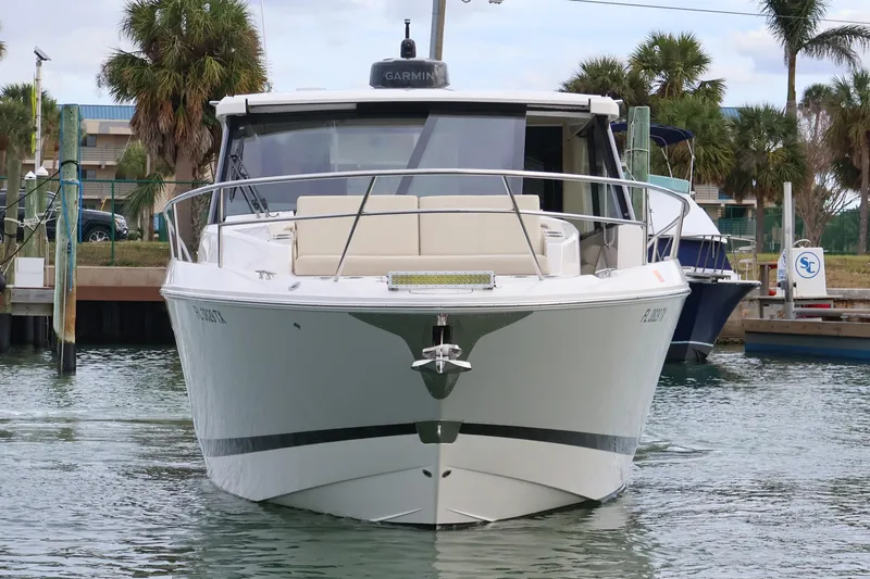 Slide: The Image of 2022 Regal 36 XO boat cruising on a calm waterway with palm trees in the background. - 5