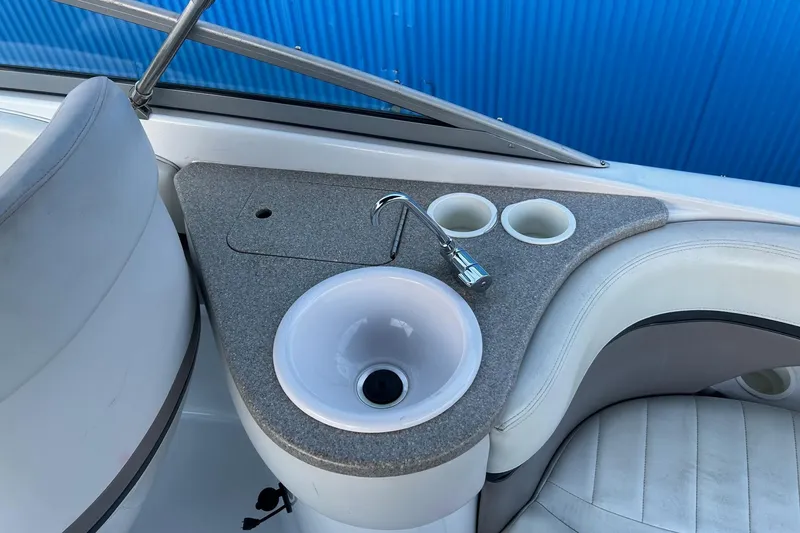 Slide: The Image of 2003 Four Winns 225 Sundowner boat interior with sink and cup holders. - 21