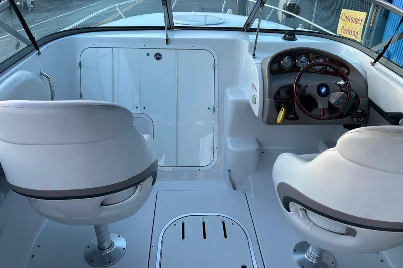 Slide: The Image of 2003 Four Winns 225 Sundowner boat interior with white seating and dashboard controls. - 5