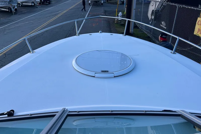 Slide: The Image of 2003 Four Winns 225 Sundowner boat deck with hatch, parked near a road. - 8