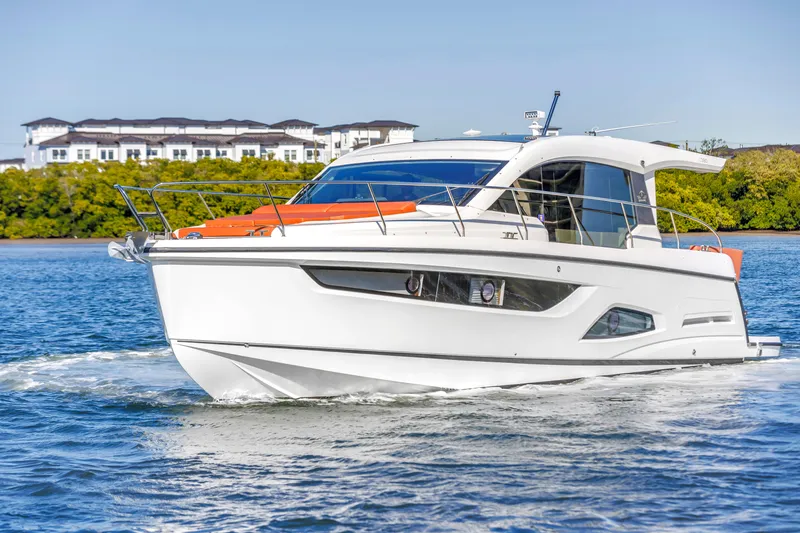 Slide: The Image of 2020 Sealine C390 yacht cruising on a sunny day near coastal buildings. - 1