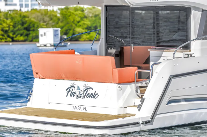 Slide: The Image of 2020 Sealine C390 yacht with orange seating, docked in Tampa, FL, named "Fin & Tonic." - 13