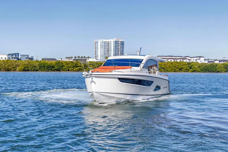 Slide: The Image of 2020 Sealine C390 yacht cruising on a sunny day near modern waterfront buildings. - 14