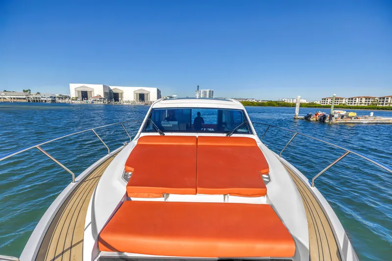 Slide: The Image of 2020 Sealine C390 yacht with orange sunbeds on deck, docked in a marina. - 15