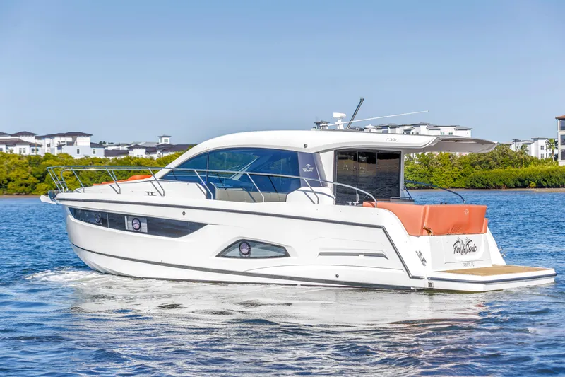 Slide: The Image of 2020 Sealine C390 yacht cruising on a sunny day near waterfront homes. - 2