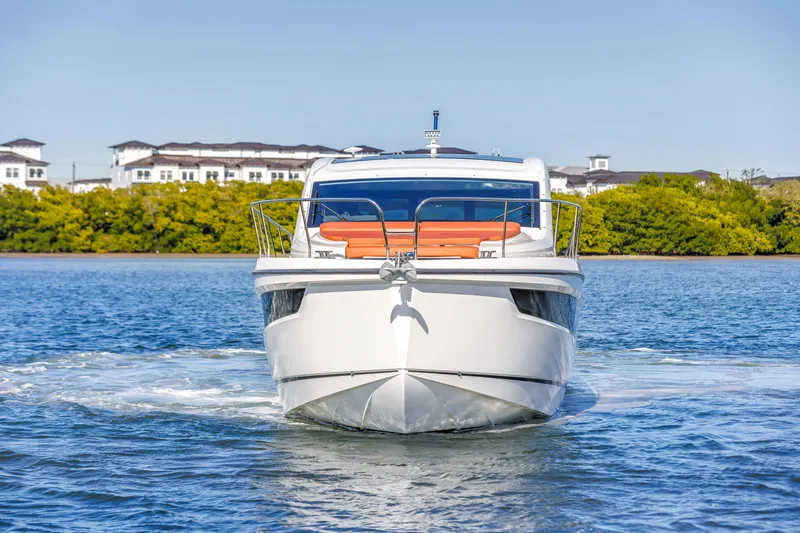 Slide: The Image of 2020 Sealine C390 yacht cruising on a sunny day, with scenic waterfront backdrop. - 5