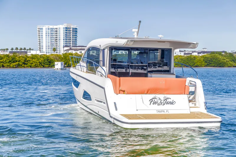 Slide: The Image of 2020 Sealine C390 yacht cruising in Tampa Bay, Florida, with modern waterfront buildings. - 9