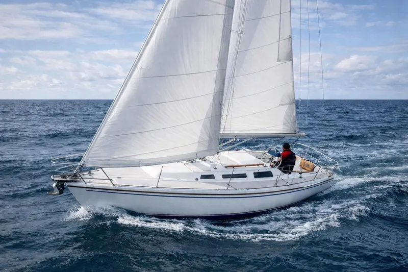 The Image of 1986 Catalina 36 sailboat navigating open sea under clear skies. - 0
