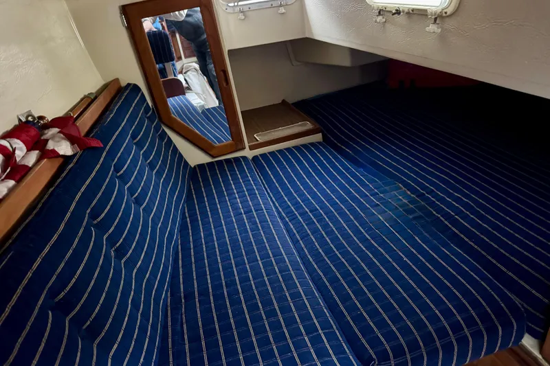 Slide: The Image of Interior cabin of 1986 Catalina 36 sailboat with blue striped cushions and a mirror. - 10