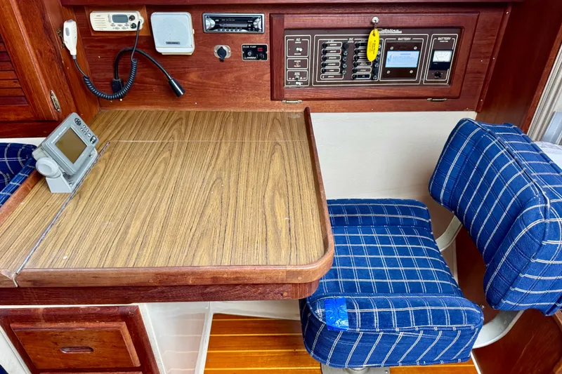 Slide: The Image of Navigation station of a 1986 Catalina 36 sailboat with blue plaid seating. - 11