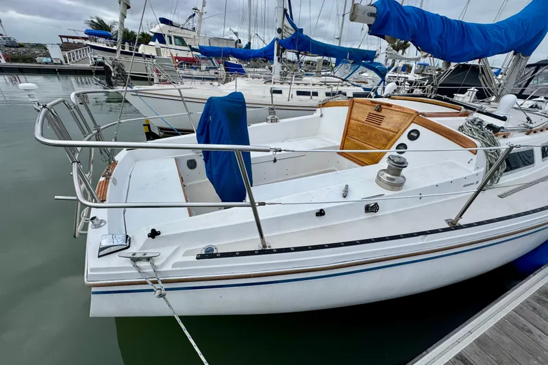 Slide: The Image of 1986 Catalina 36 sailboat docked in marina, featuring spacious cockpit and classic design. - 2