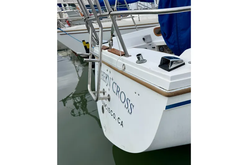 Slide: The Image of 1986 Catalina 36 sailboat stern view in marina, featuring stainless steel railings. - 4