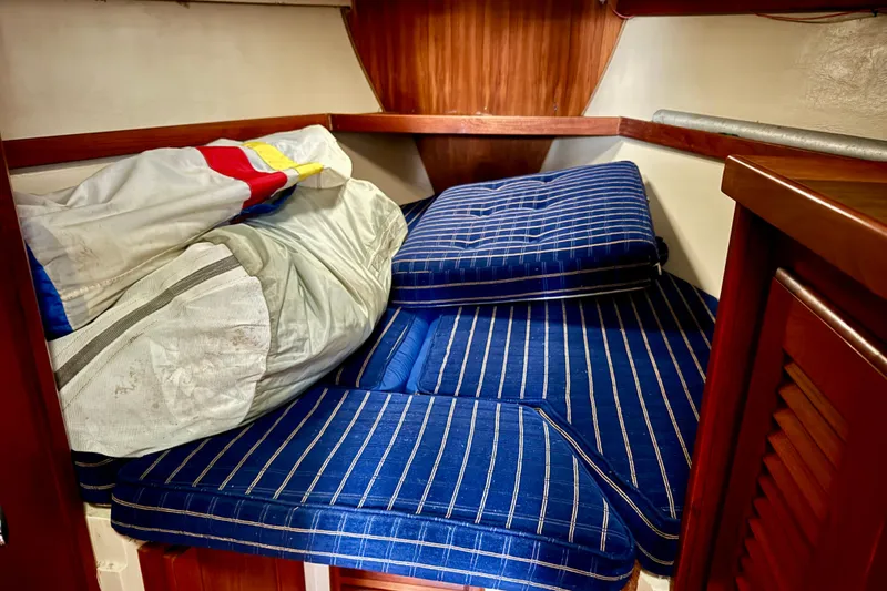 Slide: The Image of Cozy cabin interior of 1986 Catalina 36 sailboat with striped cushions and stored sail. - 5