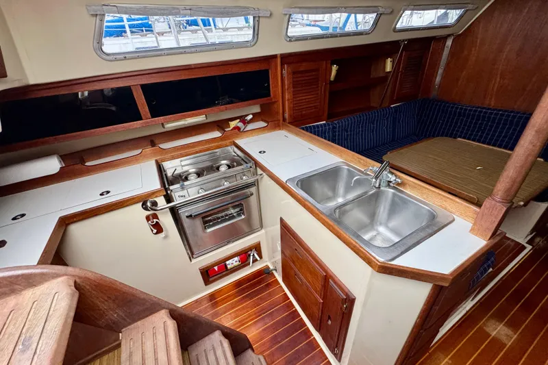 Slide: The Image of Interior of 1986 Catalina 36 sailboat featuring kitchen, stove, sink, and seating area. - 9