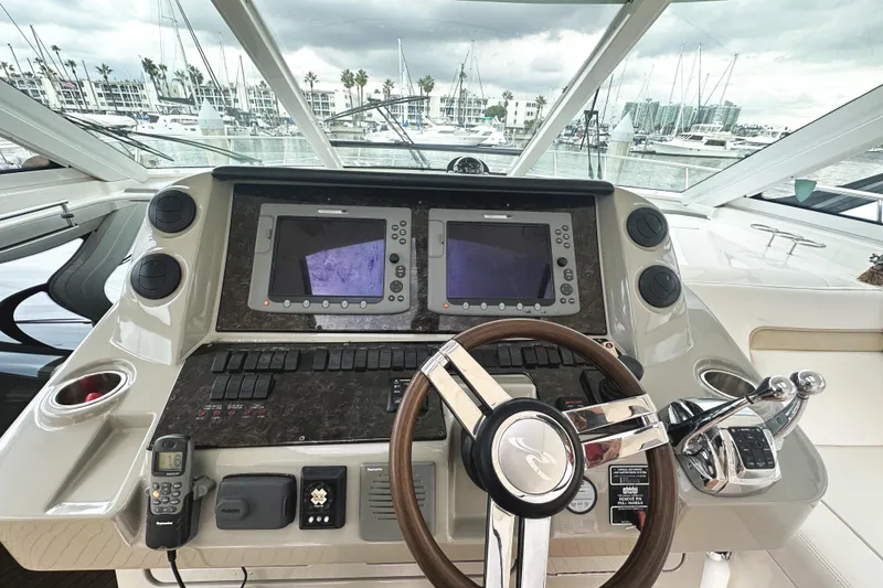 Slide: The Image of Cockpit of 2010 Sea Ray Sundancer 540 yacht with dual navigation screens and steering wheel. - 25