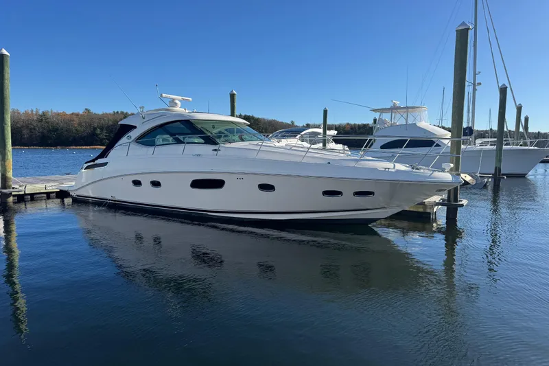 The Image of 2010 Sea Ray 470 Sundancer yacht docked in a marina on a clear day. - 0