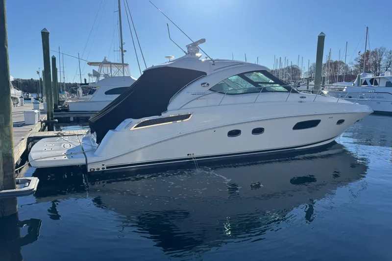 Slide: The Image of 2010 Sea Ray 470 Sundancer yacht docked at marina under clear blue sky. - 2