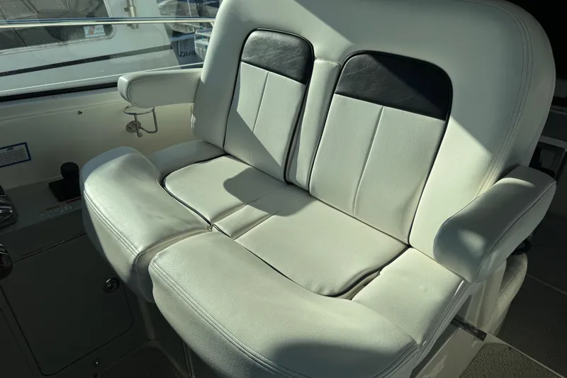 Slide: The Image of 2010 Sea Ray 470 Sundancer helm seat with white leather upholstery and armrests. - 30