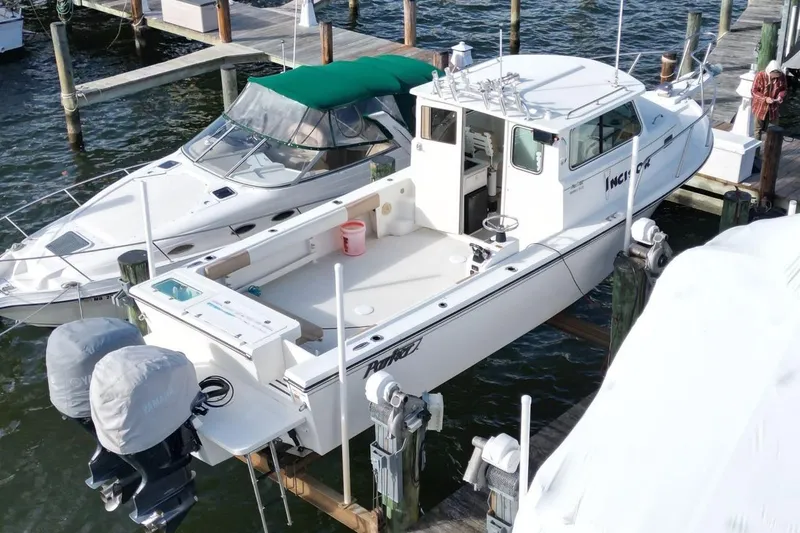 Slide: The Image of 2017 Parker 2820 XLD Sport Cabin boat docked at marina with twin outboard engines. - 7
