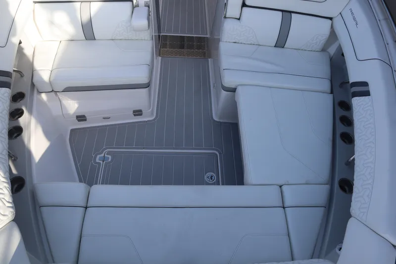 Slide: The Image of 2022 Regal LX36 boat interior with white seating and gray flooring. - 30