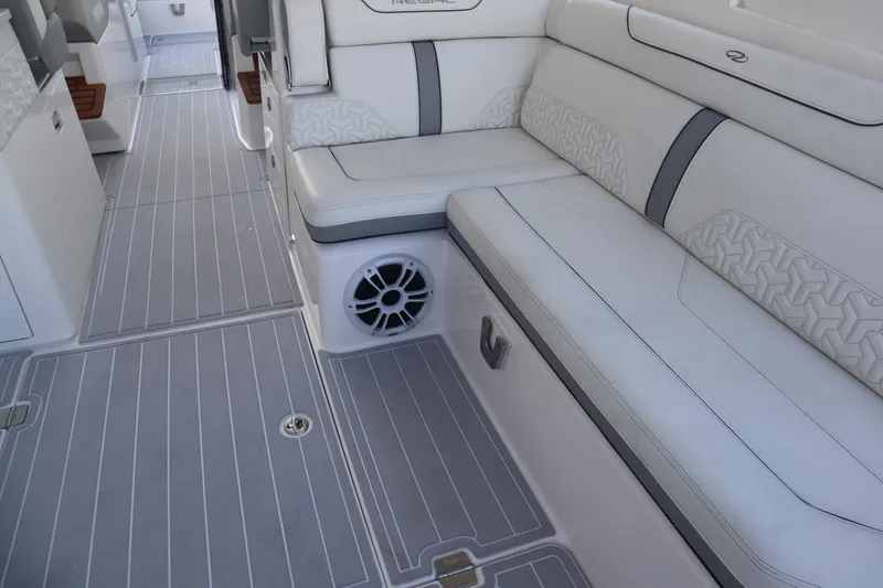 Slide: The Image of 2022 Regal LX36 boat interior with white seating and gray flooring. - 35