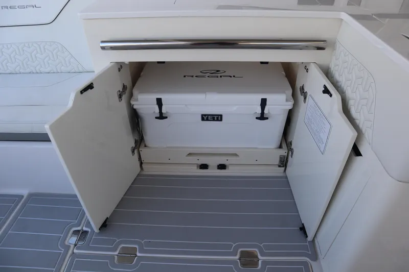 Slide: The Image of 2022 Regal LX36 boat with Yeti cooler storage compartment open. - 46