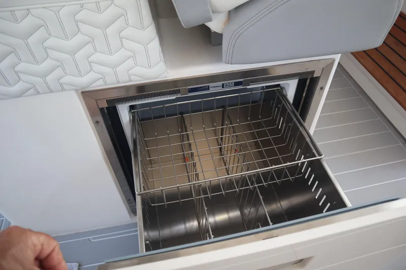 Slide: The Image of Open drawer refrigerator on 2022 Regal LX36 boat, featuring stainless steel interior and wire baskets. - 47