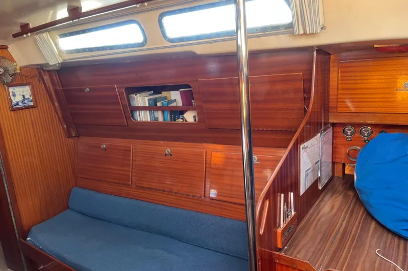 Slide: The Image of Interior of a 1975 Contest 36 sailboat with wooden cabinetry and blue seating. - 12