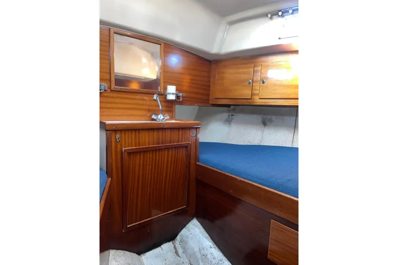 Slide: The Image of 1975 Contest 36 yacht interior with wooden cabinetry and blue cushioned seating. - 19