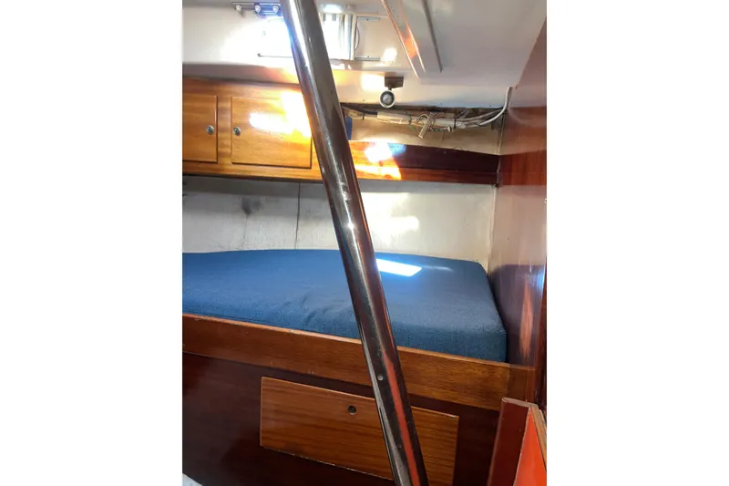 Slide: The Image of Interior cabin of a 1975 Contest 36 sailboat with wooden furnishings and blue bedding. - 20