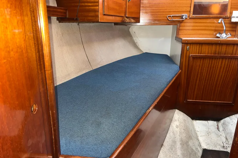 Slide: The Image of 1975 Contest 36 yacht interior with wooden cabinetry and blue cushioned berth. - 21
