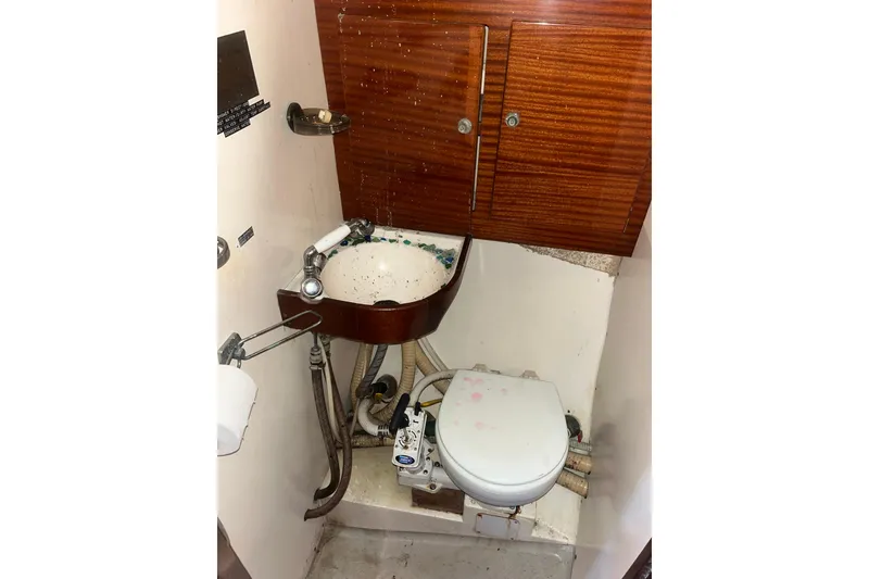 Slide: The Image of 1975 Contest 36 boat bathroom with wooden cabinets, sink, and marine toilet. - 22
