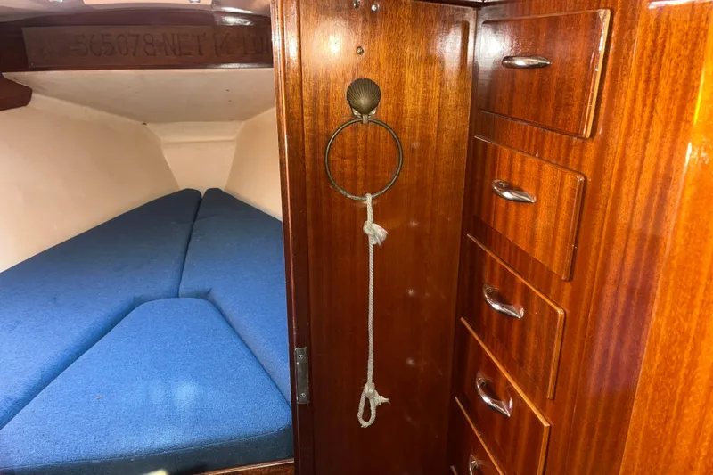 Slide: The Image of 1975 Contest 36 yacht interior with blue cushions and wooden cabinetry. - 23