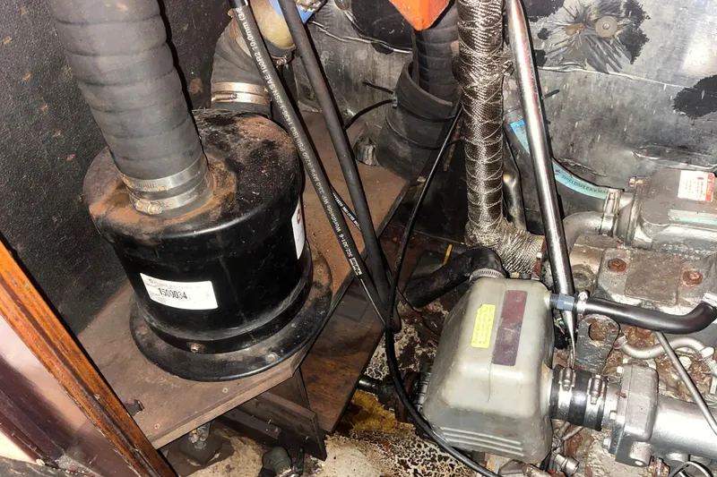 Slide: The Image of Engine compartment of a 1975 Contest 36 boat, showing various mechanical components and hoses. - 27