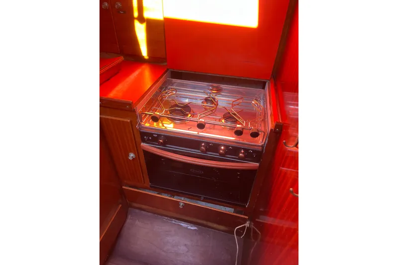 Slide: The Image of 1975 Contest 36 yacht kitchen with stove and red cabinetry. - 7