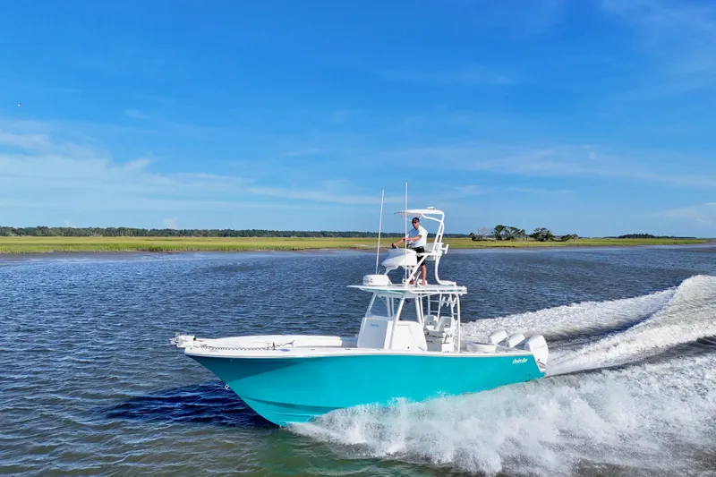 Slide: The Image of 2021 Onslow Bay 33 Tournament boat cruising on water with lush green shoreline. - 1