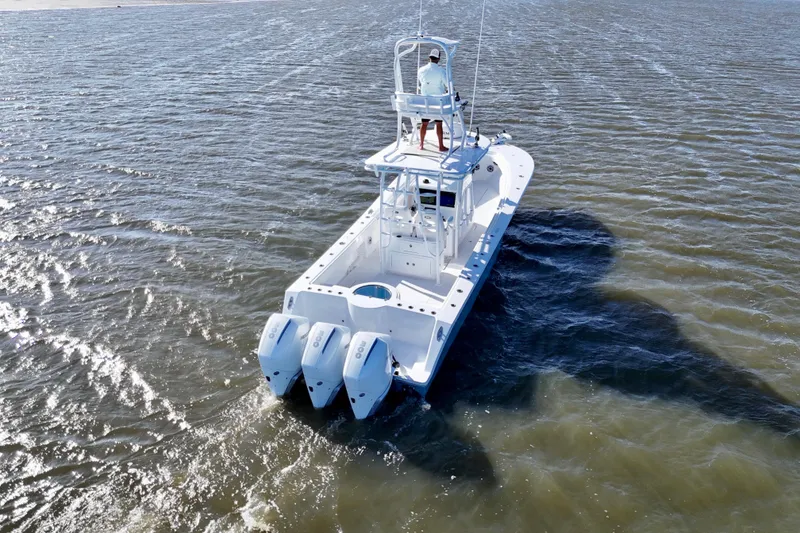 Slide: The Image of 2021 Onslow Bay 33 Tournament boat cruising on open water, rear view. - 12