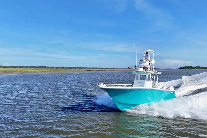 Slide: The Image of 2021 Onslow Bay 33 Tournament boat cruising on open water under clear blue sky. - 2