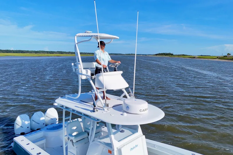 Slide: The Image of 2021 Onslow Bay 33 Tournament boat on water, with person steering from upper deck. - 20