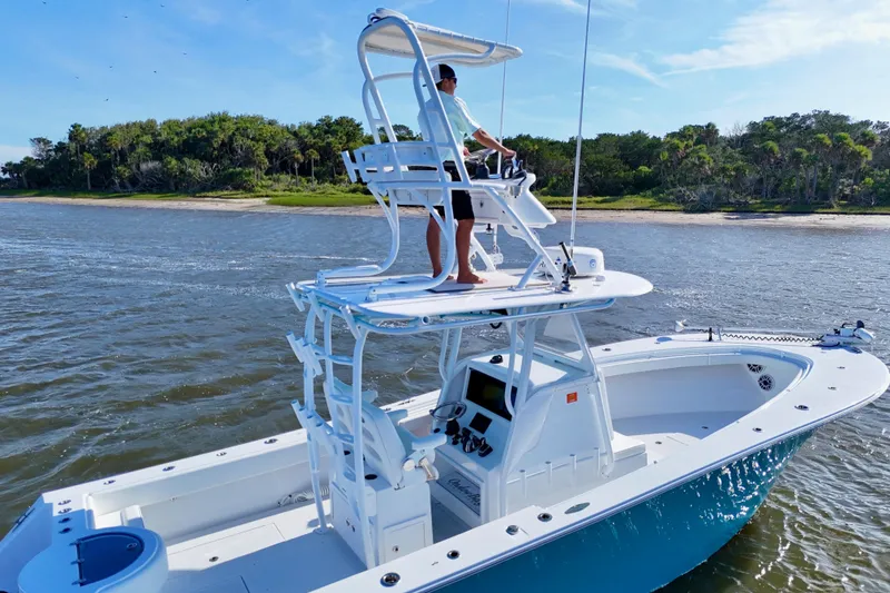 Slide: The Image of 2021 Onslow Bay 33 Tournament boat cruising near lush shoreline. - 23