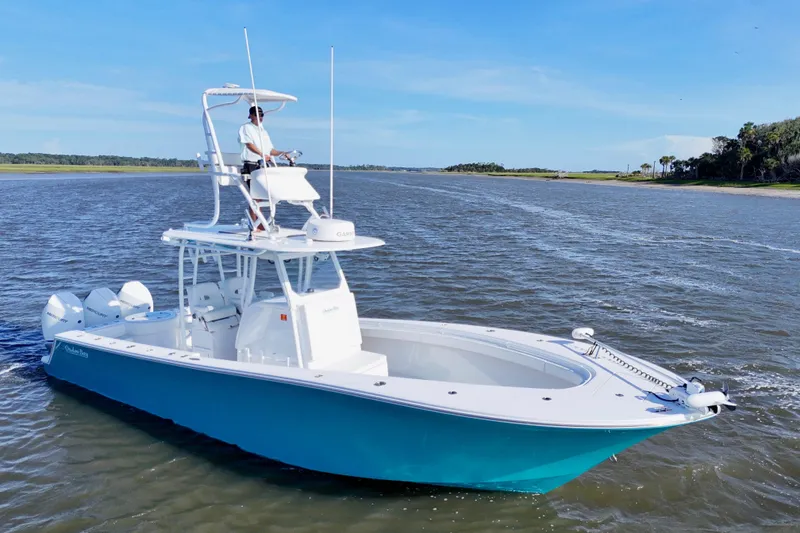 Slide: The Image of 2021 Onslow Bay 33 Tournament boat cruising on a sunny day with a person at the helm. - 25