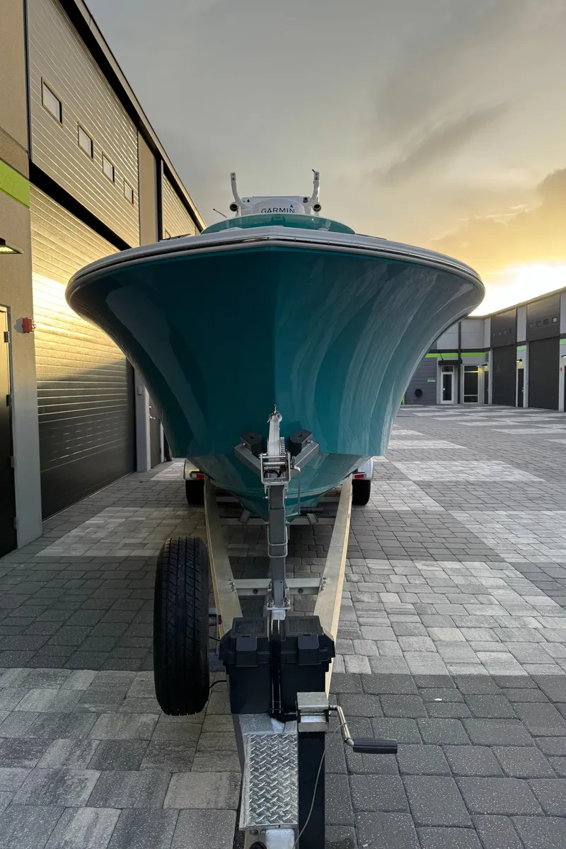 Slide: The Image of 2020 Onslow Bay 33 Tournament boat on trailer, parked in industrial area at sunset. - 57